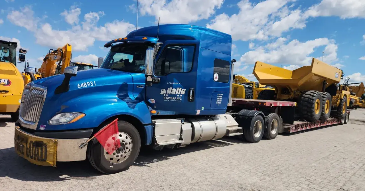 blue semi truck moves dump truck freight